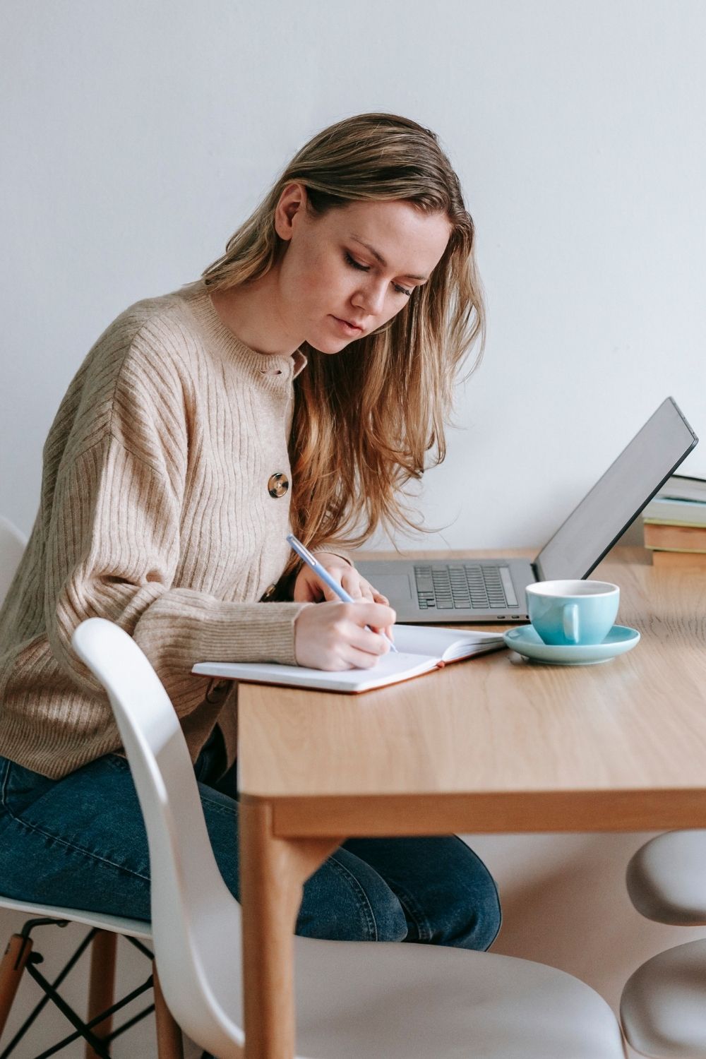 Frau schreibt konzentriert in Notizbuch - handschriftliche 5-Minuten-Auszeit für sich selbst